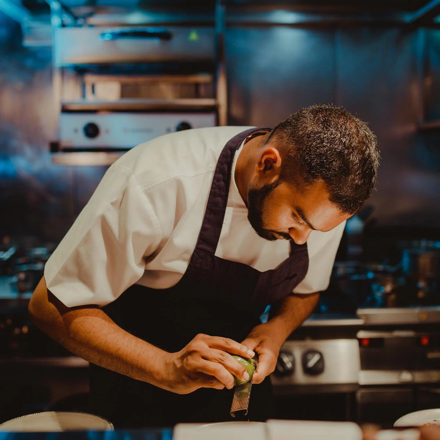 Chef preparing food in a professional kitchen.